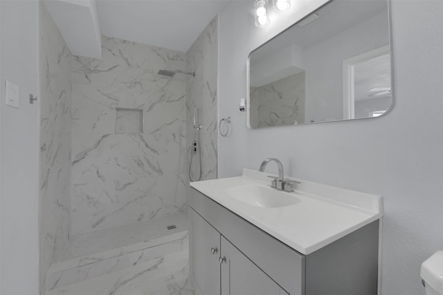 full bathroom with toilet, marble finish floor, a marble finish shower, and vanity