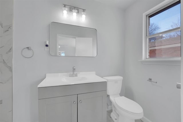 bathroom featuring baseboards, vanity, and toilet