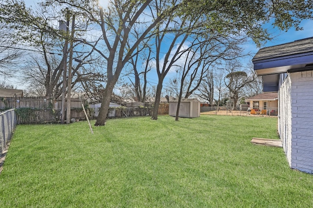 view of yard featuring a storage shed, an outdoor structure, and a fenced backyard