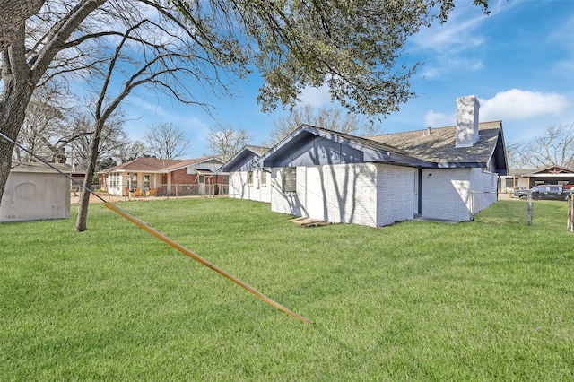 view of yard featuring fence, an outdoor structure, and a shed