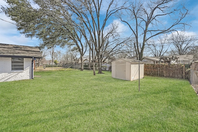 view of yard with a fenced backyard, a storage unit, and an outdoor structure