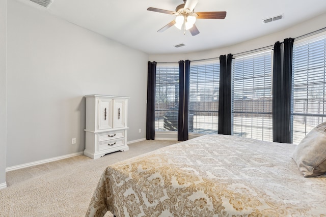 bedroom featuring ceiling fan, light colored carpet, visible vents, and baseboards