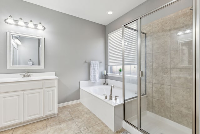 bathroom featuring tile patterned flooring, baseboards, a garden tub, a stall shower, and vanity