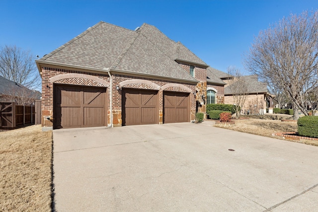 view of front of house with a garage, brick siding, roof with shingles, and concrete driveway