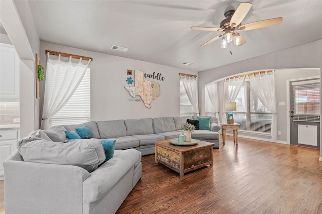 living area featuring wood finished floors, visible vents, and a ceiling fan