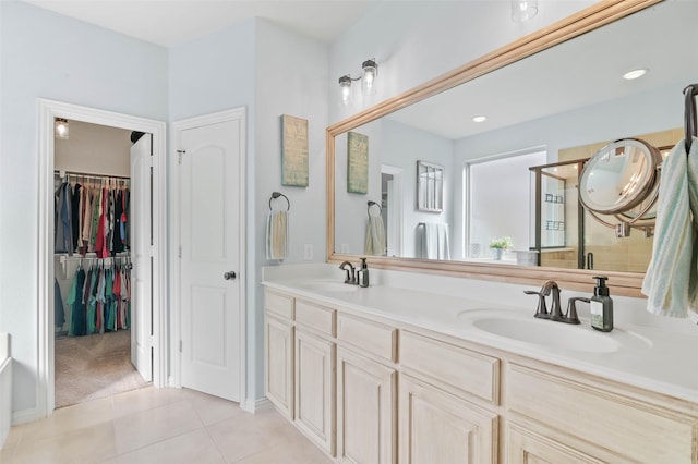 full bath with double vanity, a sink, a shower with shower door, and tile patterned floors