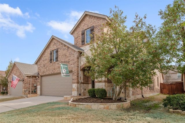 traditional-style home with a garage, stone siding, brick siding, and driveway