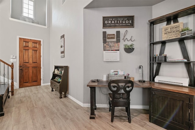 foyer featuring light wood-type flooring, stairs, and baseboards