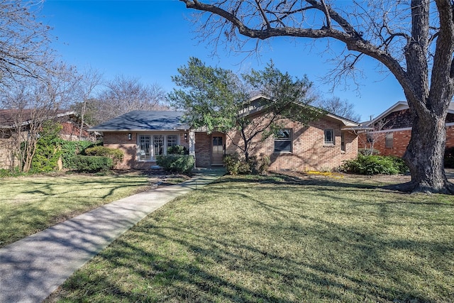 ranch-style home featuring a front lawn and brick siding