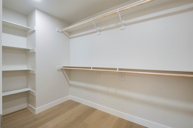 walk in closet with wood finished floors