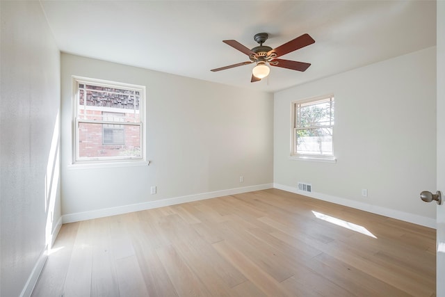 unfurnished room featuring a ceiling fan, light wood-type flooring, visible vents, and baseboards