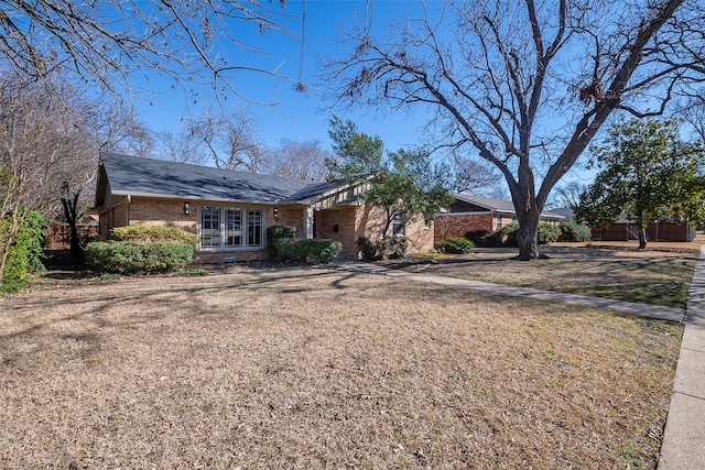 view of front of home with dirt driveway and brick siding