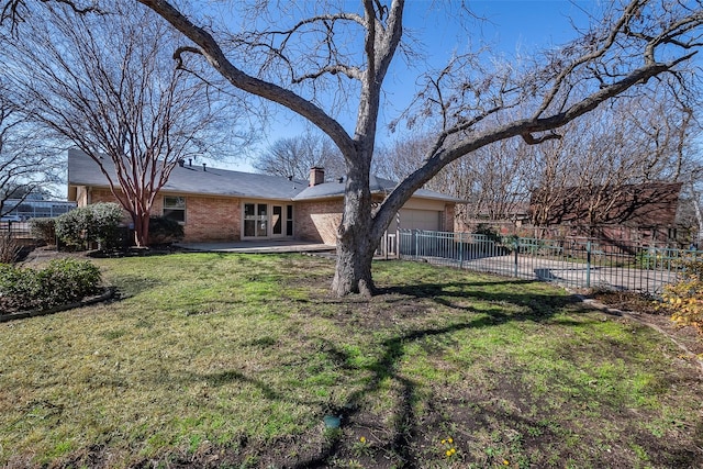 view of yard with an attached garage and fence