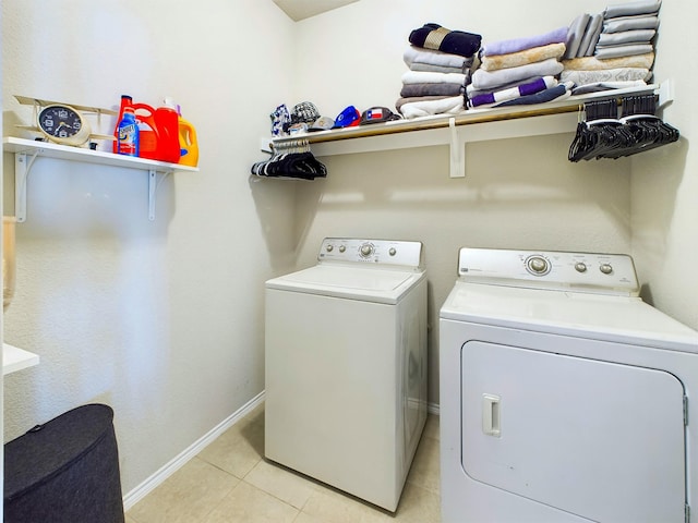 laundry area with laundry area, light tile patterned flooring, independent washer and dryer, and baseboards