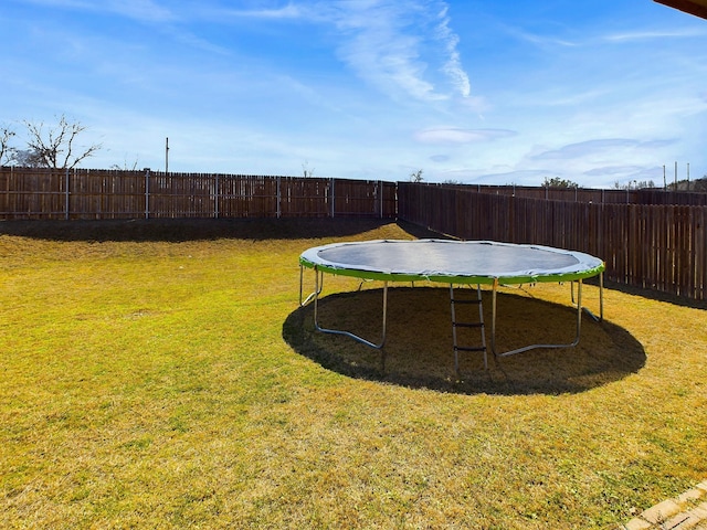 view of yard with a fenced backyard and a trampoline