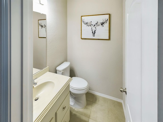 bathroom with baseboards, vanity, toilet, and tile patterned floors