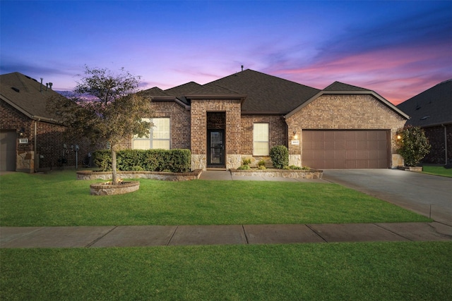 view of front of house with a garage, concrete driveway, brick siding, and a front yard