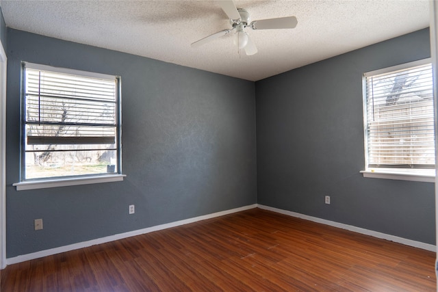 spare room featuring a ceiling fan, a textured ceiling, baseboards, and wood finished floors