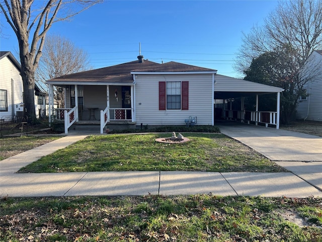 view of front of house with a carport, a porch, a front yard, and driveway