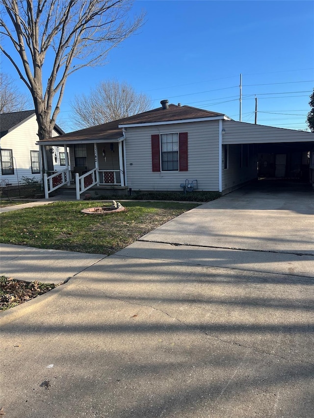 view of front of house featuring a carport, covered porch, a front lawn, and concrete driveway