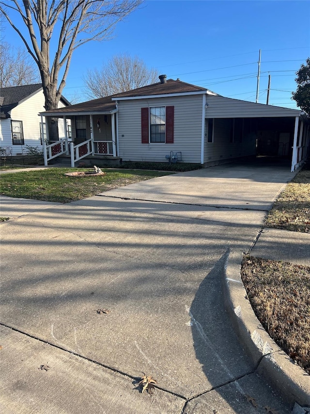 view of front of property with covered porch, a carport, and driveway