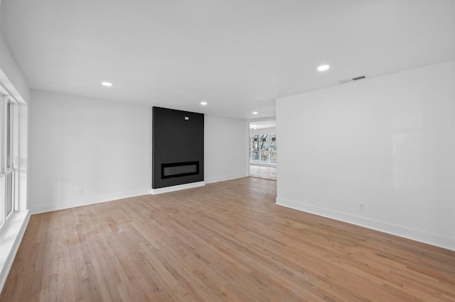 unfurnished living room featuring light wood-style floors, recessed lighting, visible vents, and a fireplace