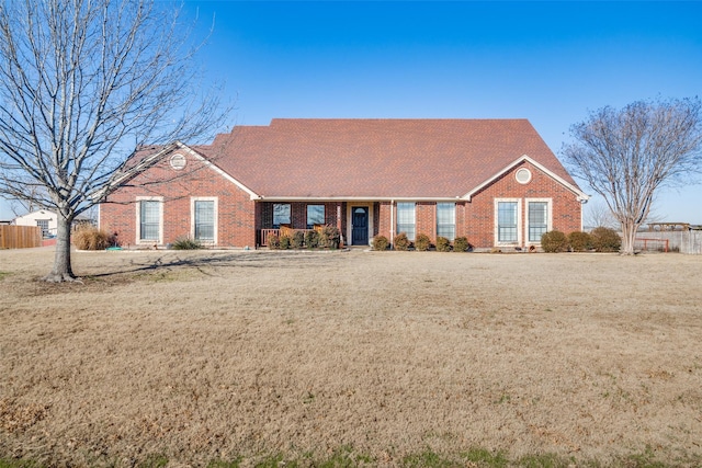 ranch-style home with brick siding, a front yard, and fence