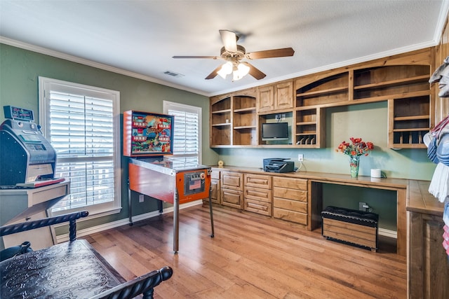 office space featuring a wealth of natural light, light wood-style flooring, visible vents, and crown molding