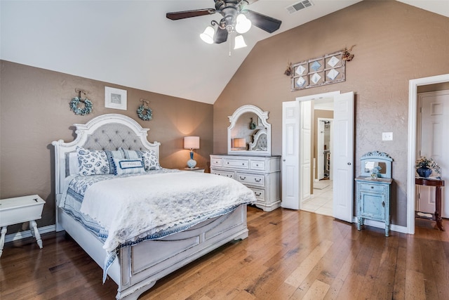 bedroom featuring visible vents, vaulted ceiling, baseboards, and hardwood / wood-style flooring