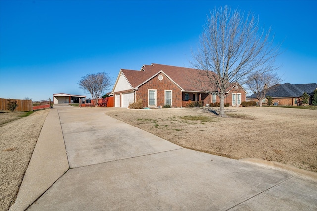 ranch-style home featuring brick siding, concrete driveway, an attached garage, fence, and a front lawn