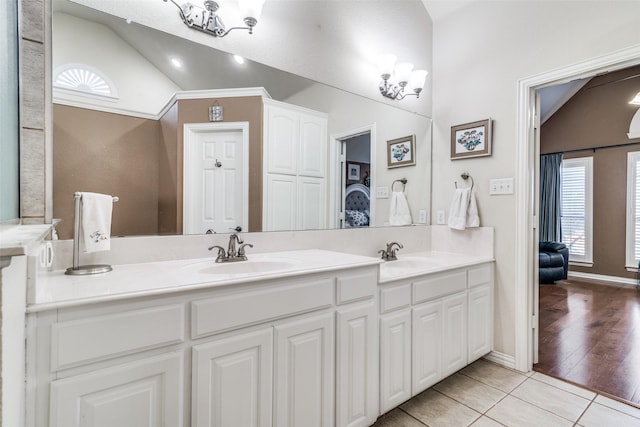 full bath featuring lofted ceiling, double vanity, tile patterned flooring, and a sink