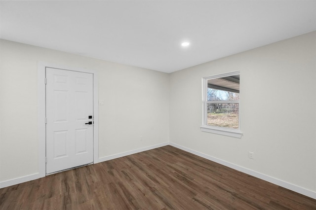 empty room with baseboards, wood finished floors, and recessed lighting