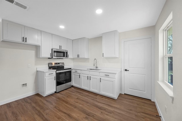 kitchen with stainless steel appliances, a sink, visible vents, and white cabinets