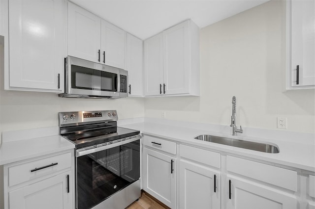 kitchen featuring stainless steel appliances, a sink, and light countertops