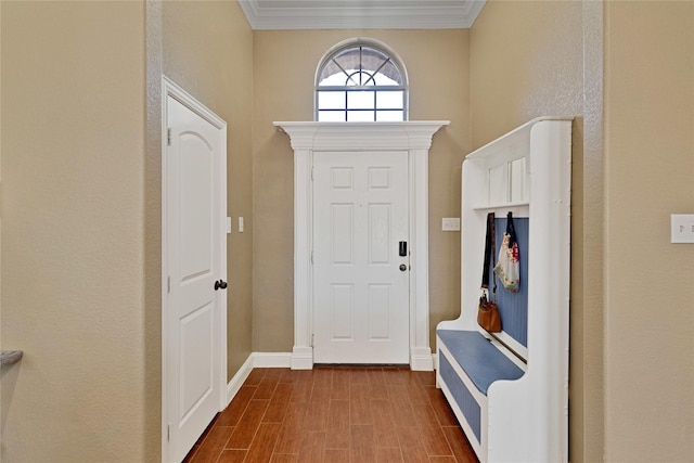 entryway featuring wood finish floors, crown molding, and baseboards