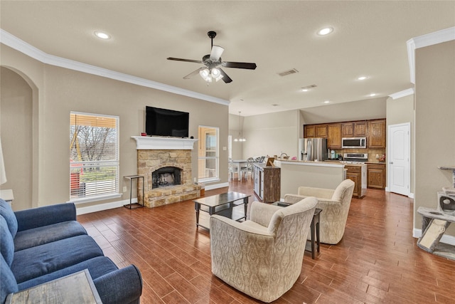 214 Willow Creek Dr, Weatherford, TX 76085 - living room featuring a fireplace, a ceiling fan, baseboards, ornamental molding, and dark wood-style floors