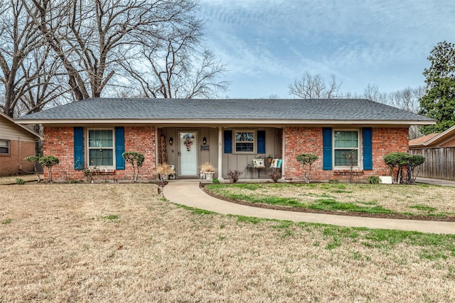 single story home with brick siding, board and batten siding, a front lawn, and roof with shingles