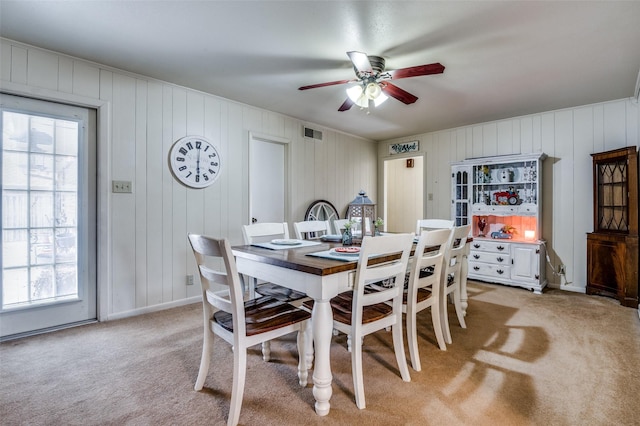 dining area featuring light carpet, visible vents, a healthy amount of sunlight, and a ceiling fan