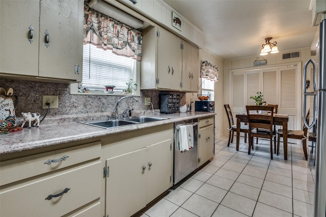 kitchen with light tile patterned floors, stainless steel appliances, light countertops, and a sink