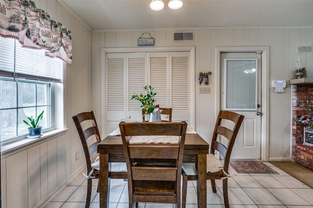 dining space featuring light tile patterned floors, visible vents, and ornamental molding