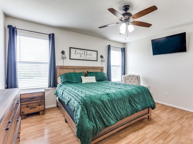 bedroom featuring light wood-type flooring, a ceiling fan, and baseboards