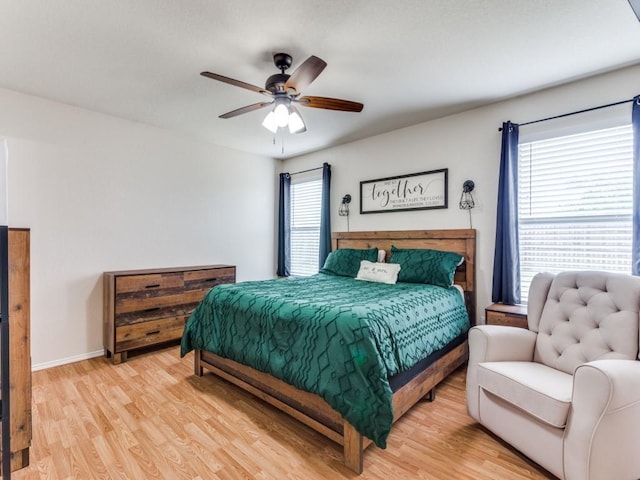 bedroom with baseboards, a ceiling fan, and light wood-style floors