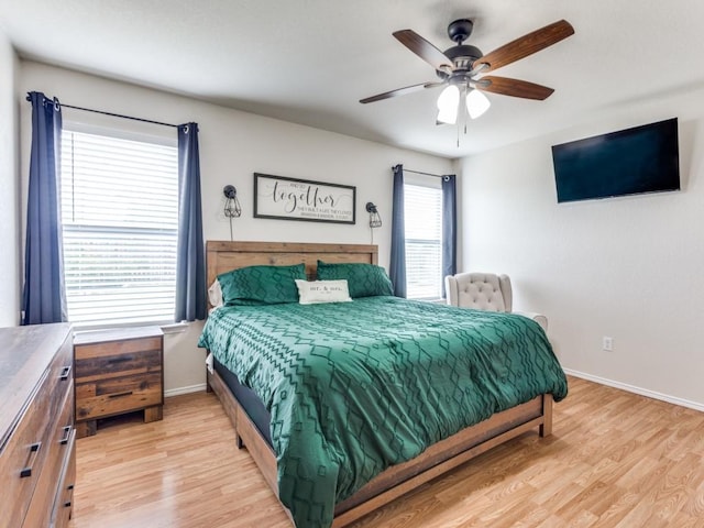 bedroom with light wood-type flooring, ceiling fan, and baseboards