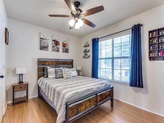 bedroom featuring light wood-style flooring, baseboards, and ceiling fan