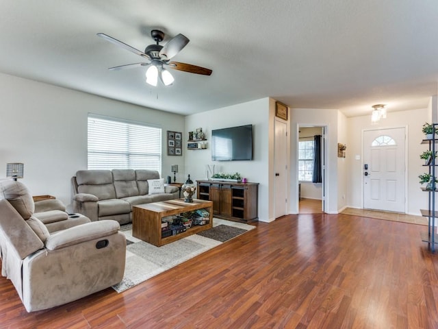 living room with baseboards, a ceiling fan, and wood finished floors
