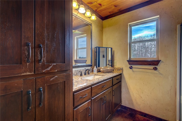 bathroom featuring a textured wall, baseboards, and vanity