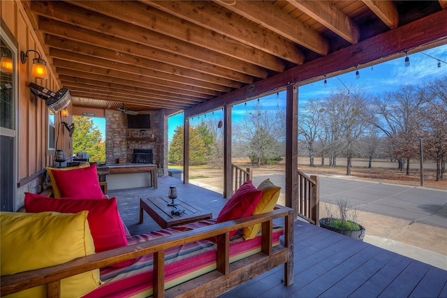 wooden deck featuring ceiling fan and an outdoor living space with a fireplace