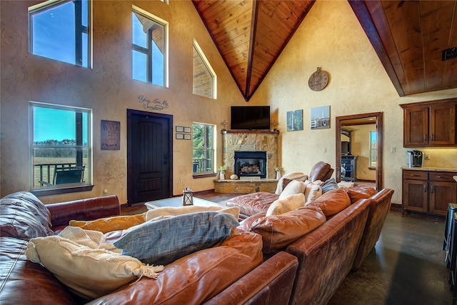 living room with finished concrete flooring, a textured wall, wood ceiling, and a stone fireplace