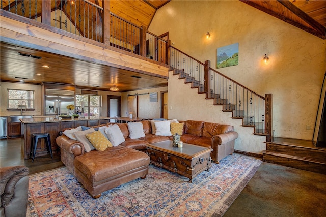 living room featuring a towering ceiling, wooden ceiling, stairs, and a textured wall