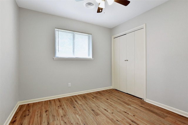 unfurnished bedroom with light wood finished floors, a closet, visible vents, ceiling fan, and baseboards